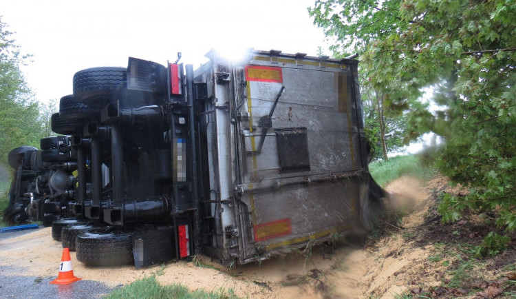Kamion havaroval a skončil na boku. Krmný šrot, který vezl, zasypal vozovku