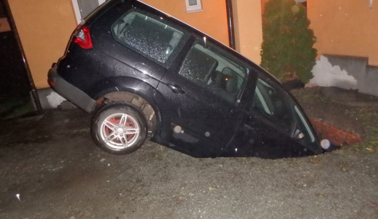 FOTO: Kuriózní nehoda. Pod autem se propadla zem a vozidlo zapadlo do jímky