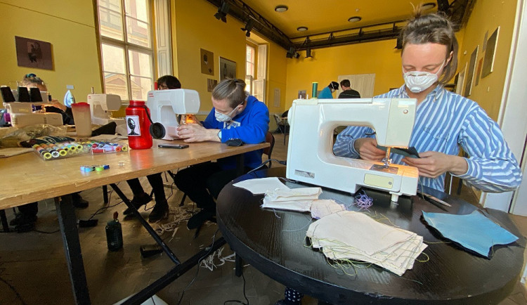 Dobrovolnice šijí roušky.