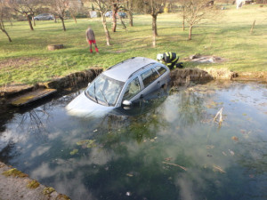 Zdemolované auto na střeše i Fabia v jezírku. Hasiči se o Velikonocích nenudili