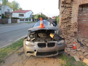 Po nehodě zůstalo osobní auto zaklíněné v domě. Řidič se spolujezdcem jsou v nemocnici