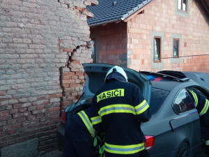 Po nehodě zůstalo osobní auto zaklíněné v domě. Řidič se spolujezdcem jsou v nemocnici