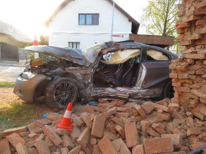 Po nehodě zůstalo osobní auto zaklíněné v domě. Řidič se spolujezdcem jsou v nemocnici