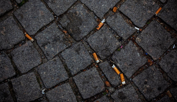 Nedopalky cigaret mezi dlažebními kostkami