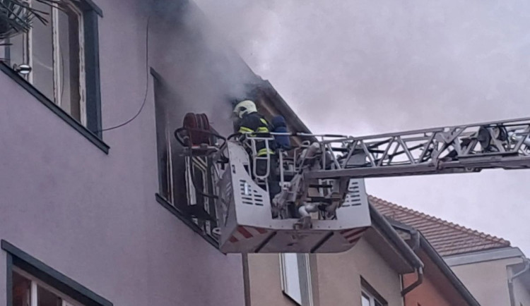 Při požáru bytového domu v Brně zemřel člověk, dalšího hasiči zachránili