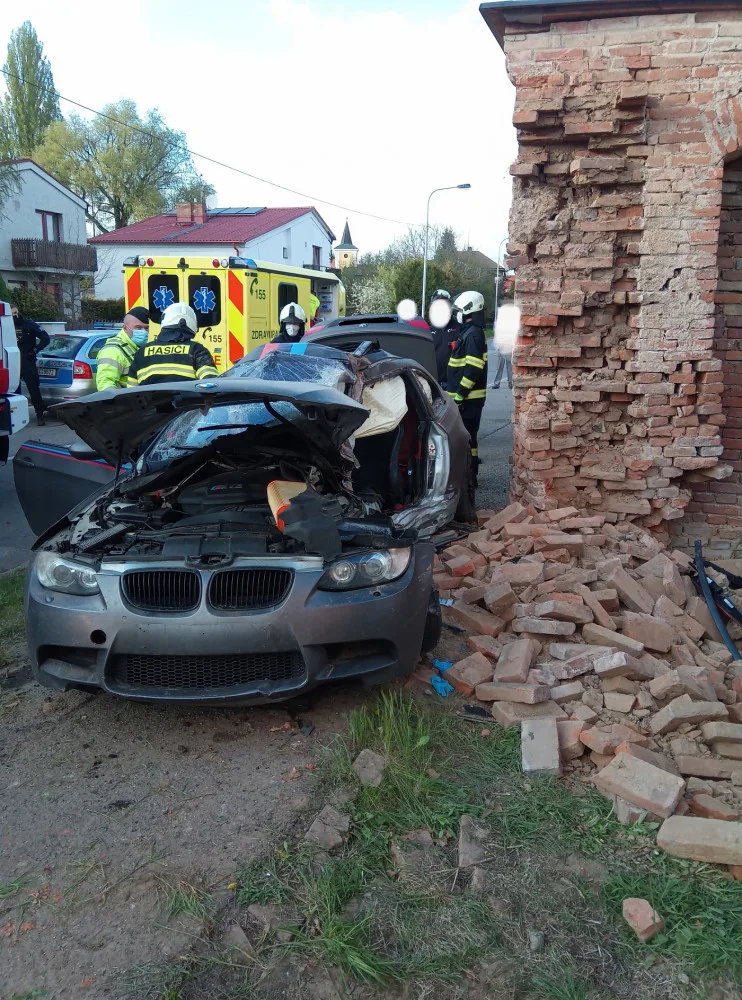 Po nehodě zůstalo osobní auto zaklíněné v domě. Řidič se spolujezdcem jsou v nemocnici