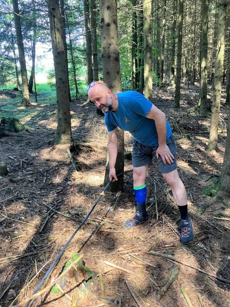 Milan Čech ukazuje, jak volně je kabel v lese položen.