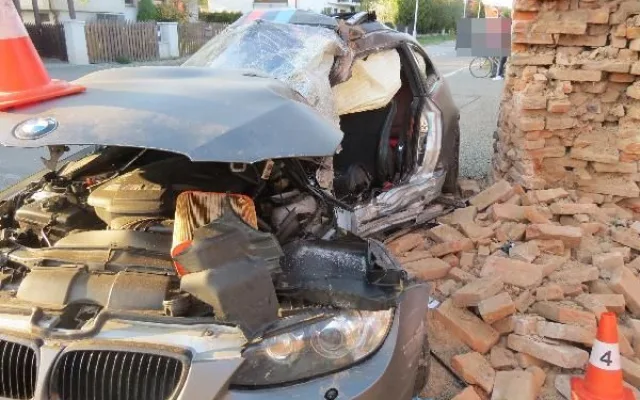 Po nehodě zůstalo osobní auto zaklíněné v domě. Řidič se spolujezdcem jsou v nemocnici