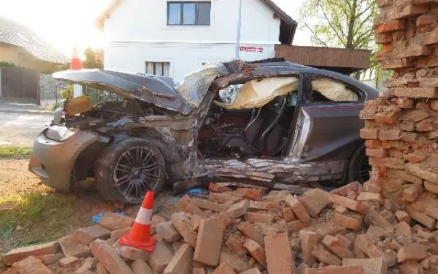 Po nehodě zůstalo osobní auto zaklíněné v domě. Řidič se spolujezdcem jsou v nemocnici