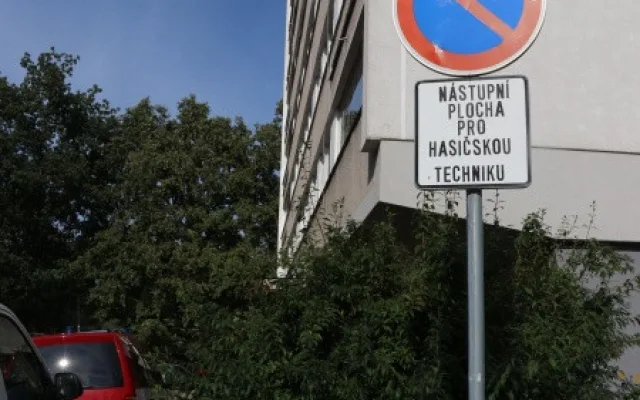 Špatně zaparkovaná auta u panelového domu