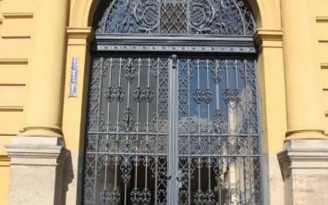 Umělecký kovář Pavel Vágner před restaurovanou mříží na budově gymnázia ve Dvoře Králové nad Labem