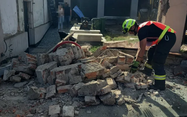 Přívěs se utrhl z náklaďáku a prorazil zeď. Hasiči ji museli zbourat