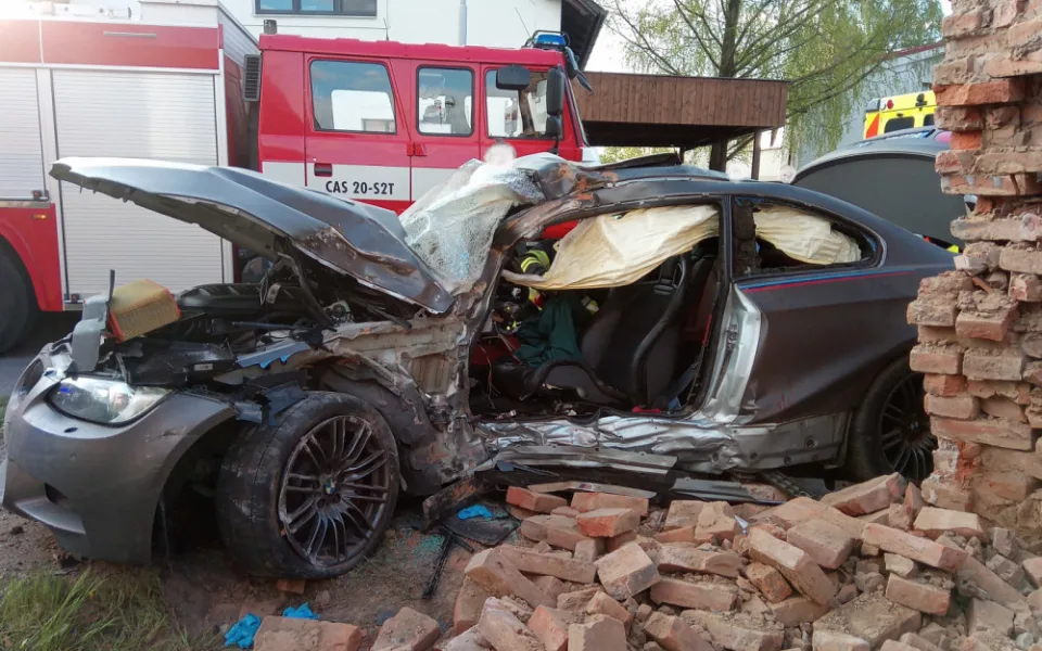 Po nehodě zůstalo osobní auto zaklíněné v domě. Řidič se spolujezdcem jsou v nemocnici