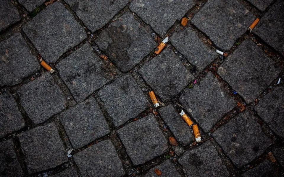 Nedopalky cigaret mezi dlažebními kostkami